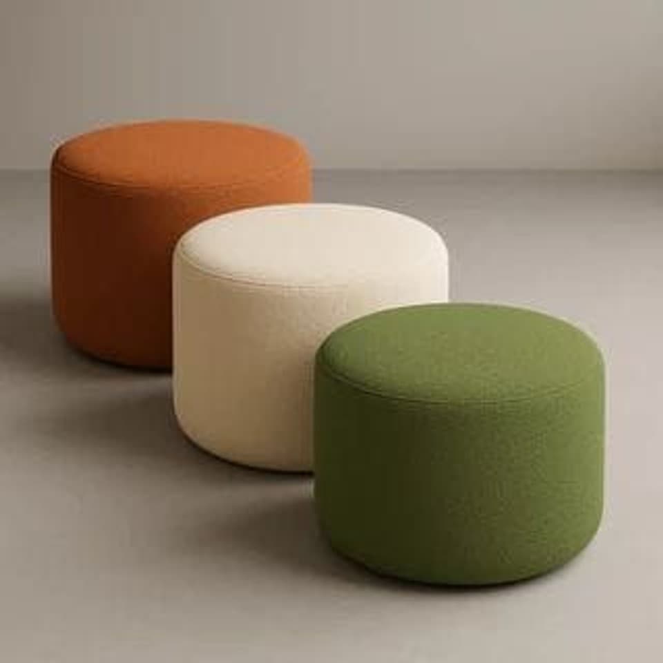 Three round bouclé ottomans in orange, cream and green